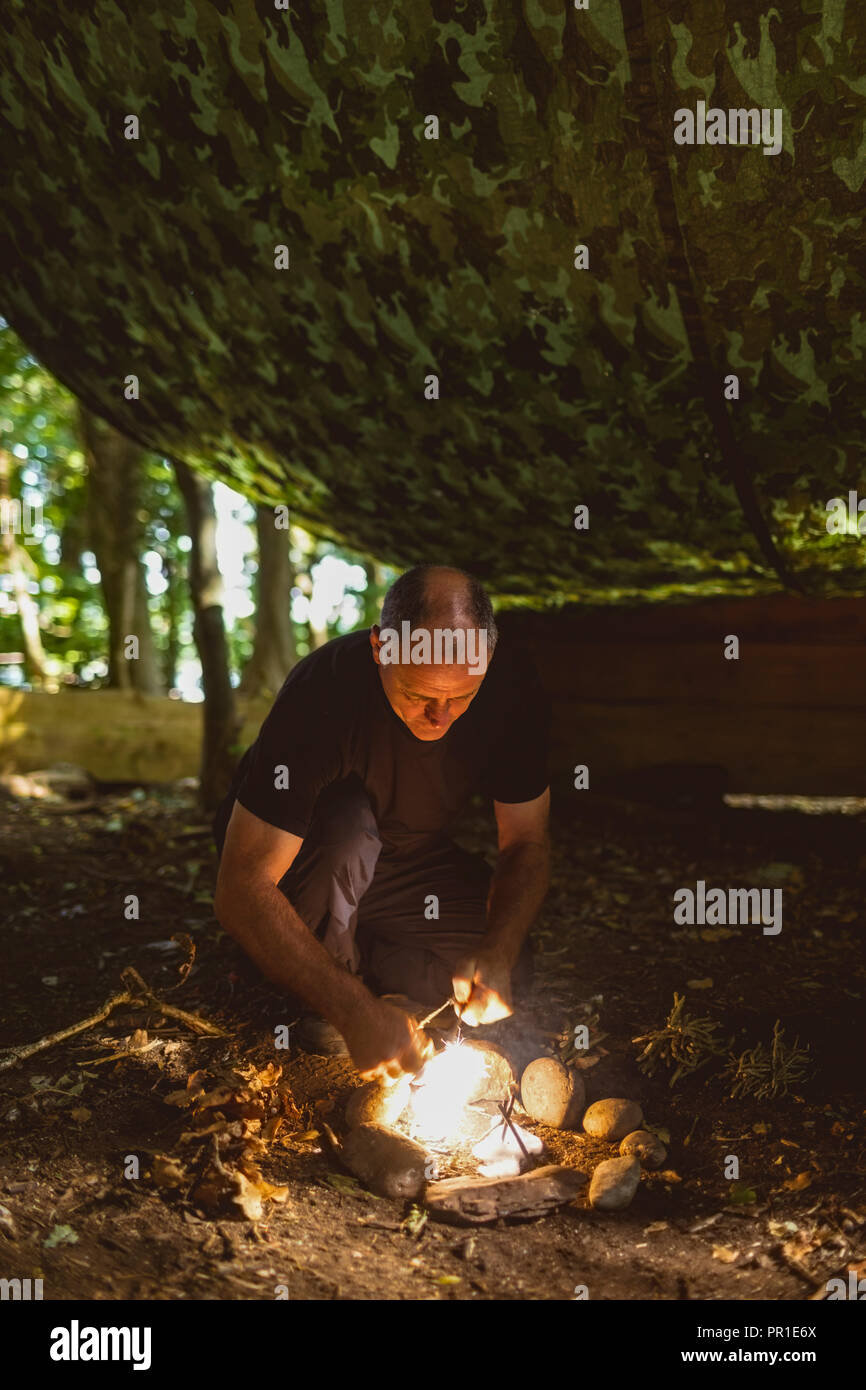 Man lighting fire at boot camp Stock Photo