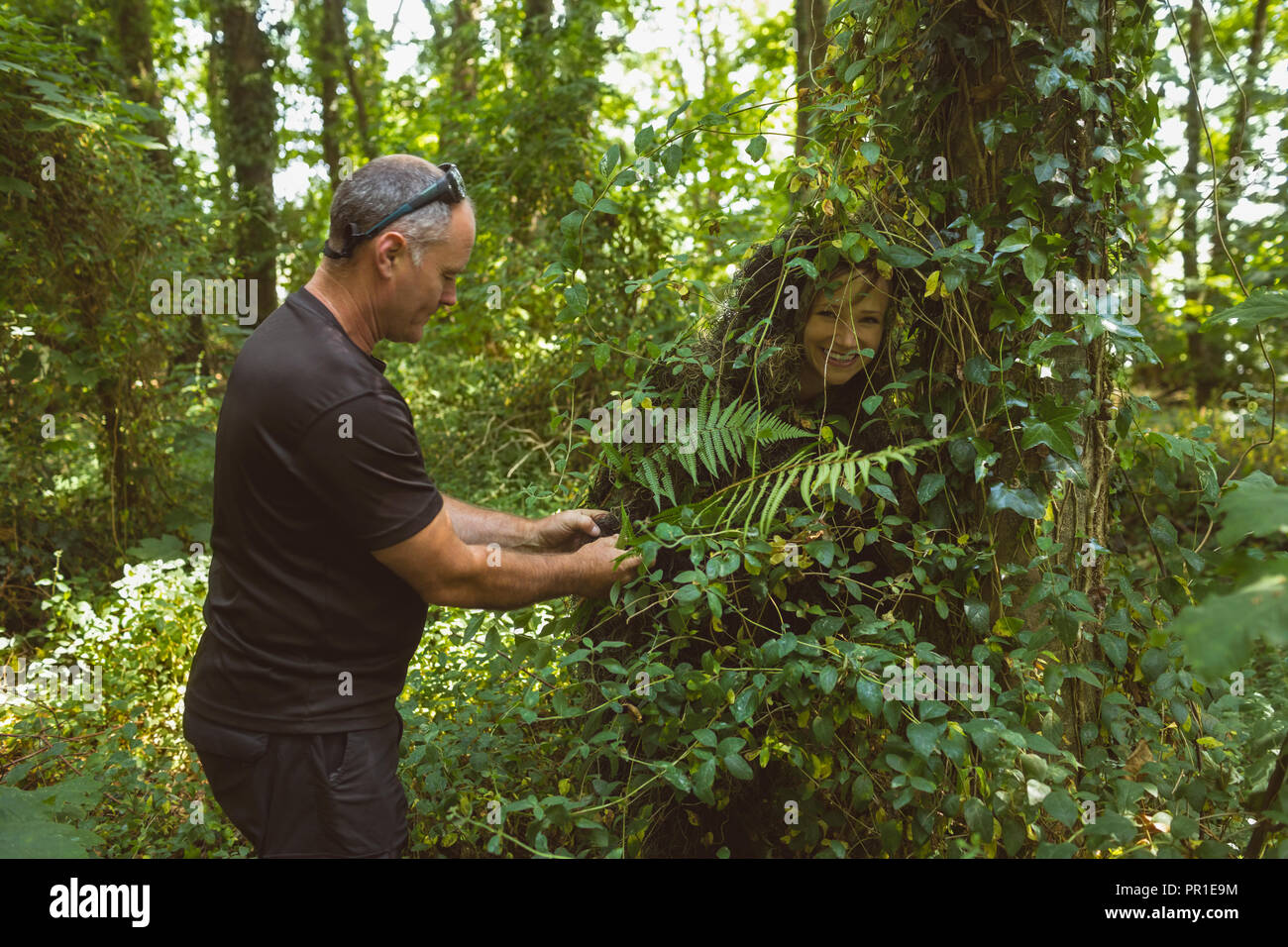 Man rescuing woman stucked in bushes Stock Photo