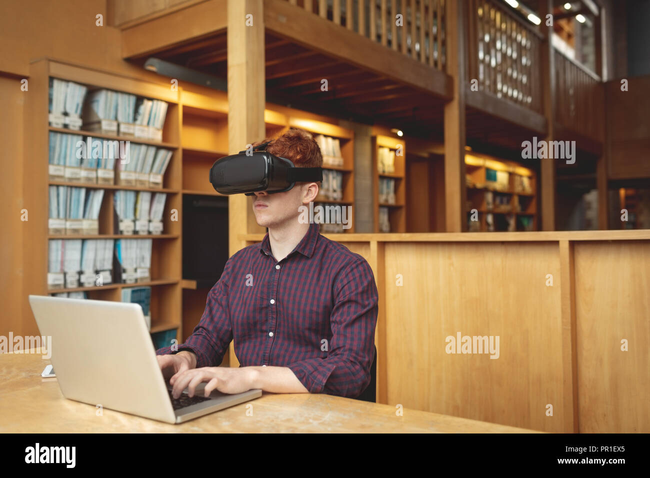 College student using laptop and virtual reality headset Stock Photo