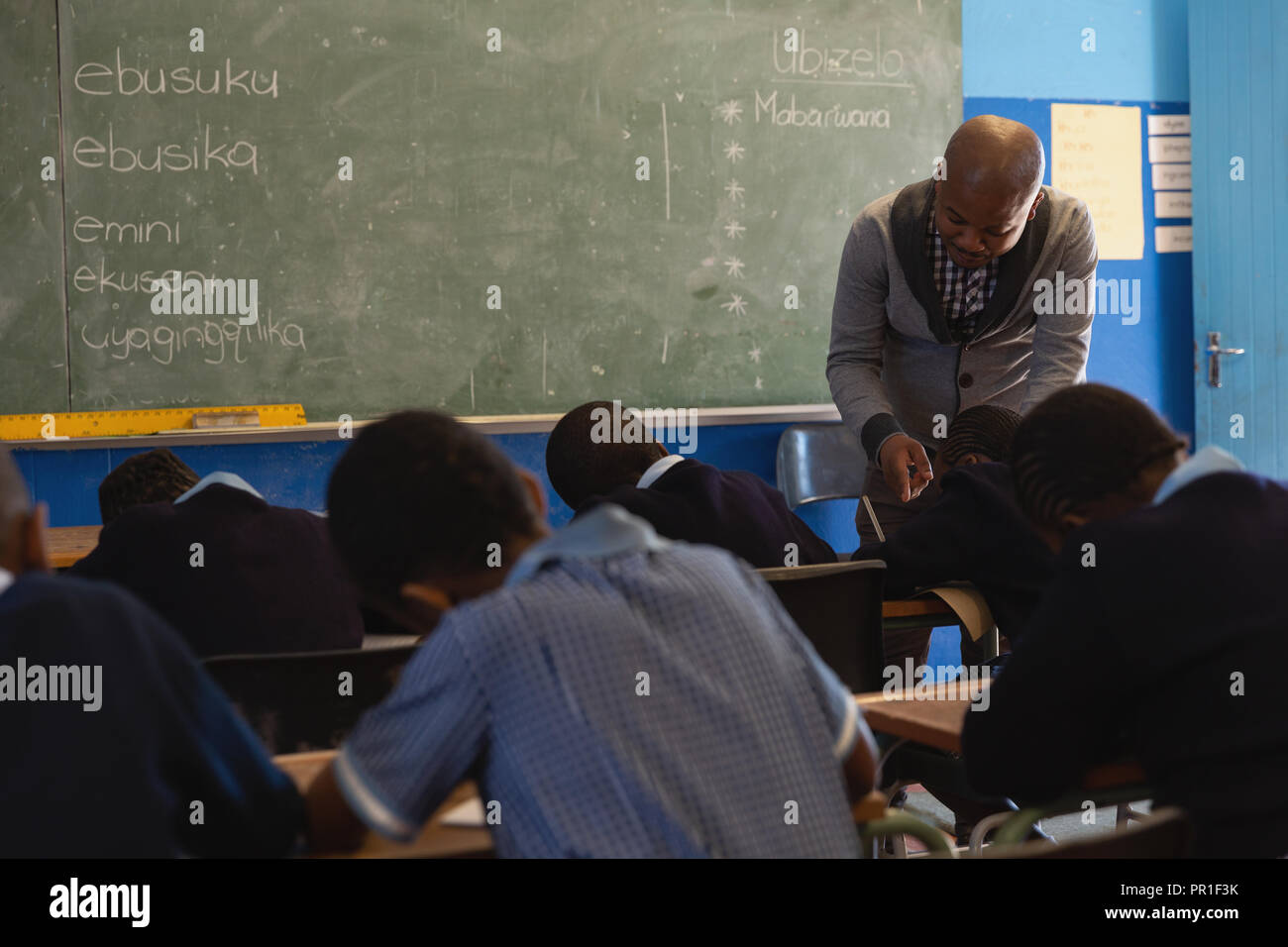 Male teacher teaching students in the class Stock Photo