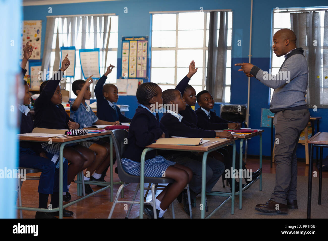 Male teacher teaching students in the classroom Stock Photo