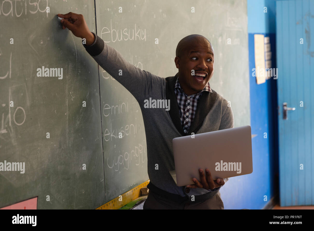 Male teacher explaining on chalkboard Stock Photo