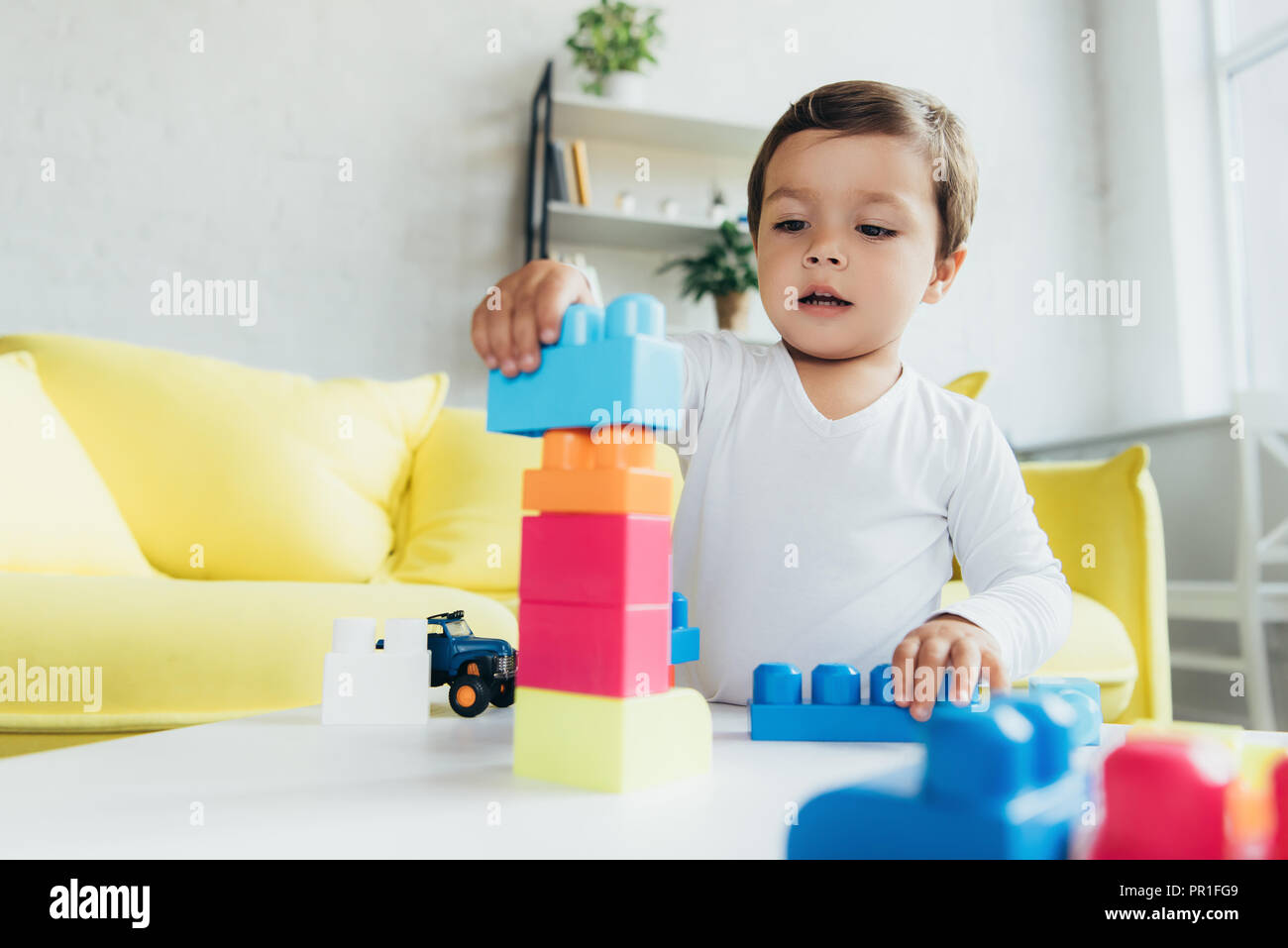 toddler playing with colorful constructor blocks at home Stock Photo ...