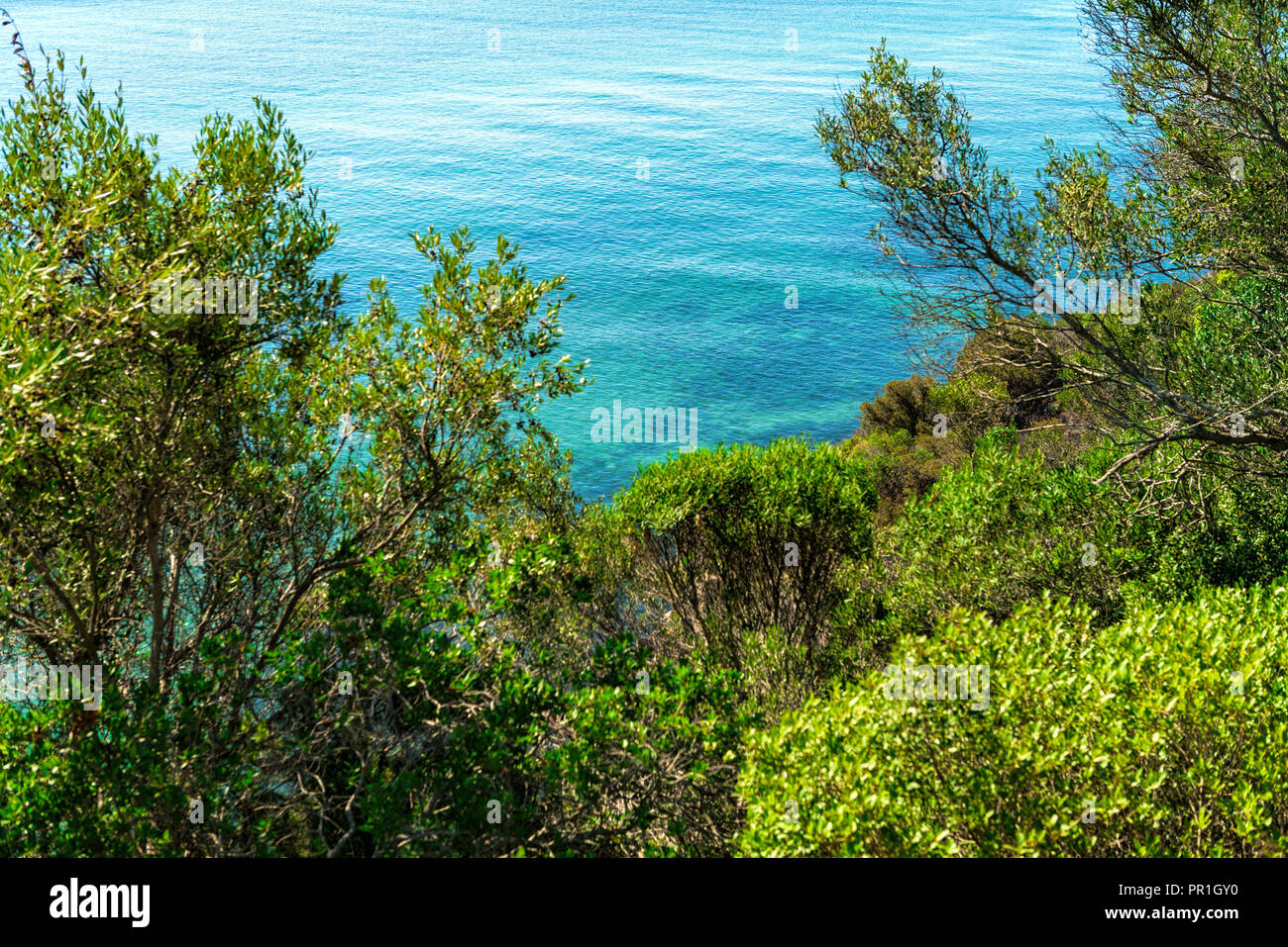 blue ocean waters near a small island at Serra da Arrabida beaches. Horizontal composition. Setubal, Portugal. Stock Photo