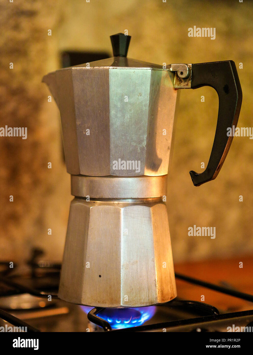 A single Moka pot brewing coffee on a stove Stock Photo