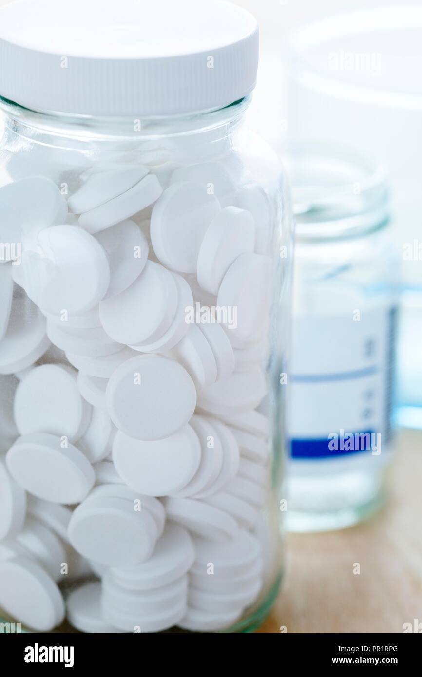 White pills in a glass bottle. Stock Photo