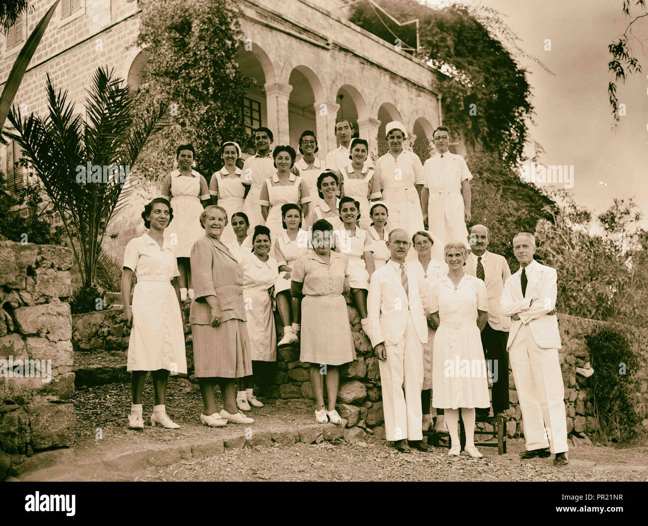 Dr. H. Torrance, Tiberias. Group. Staff with doctors house in background. 1940, Israel, Tiberias Stock Photo