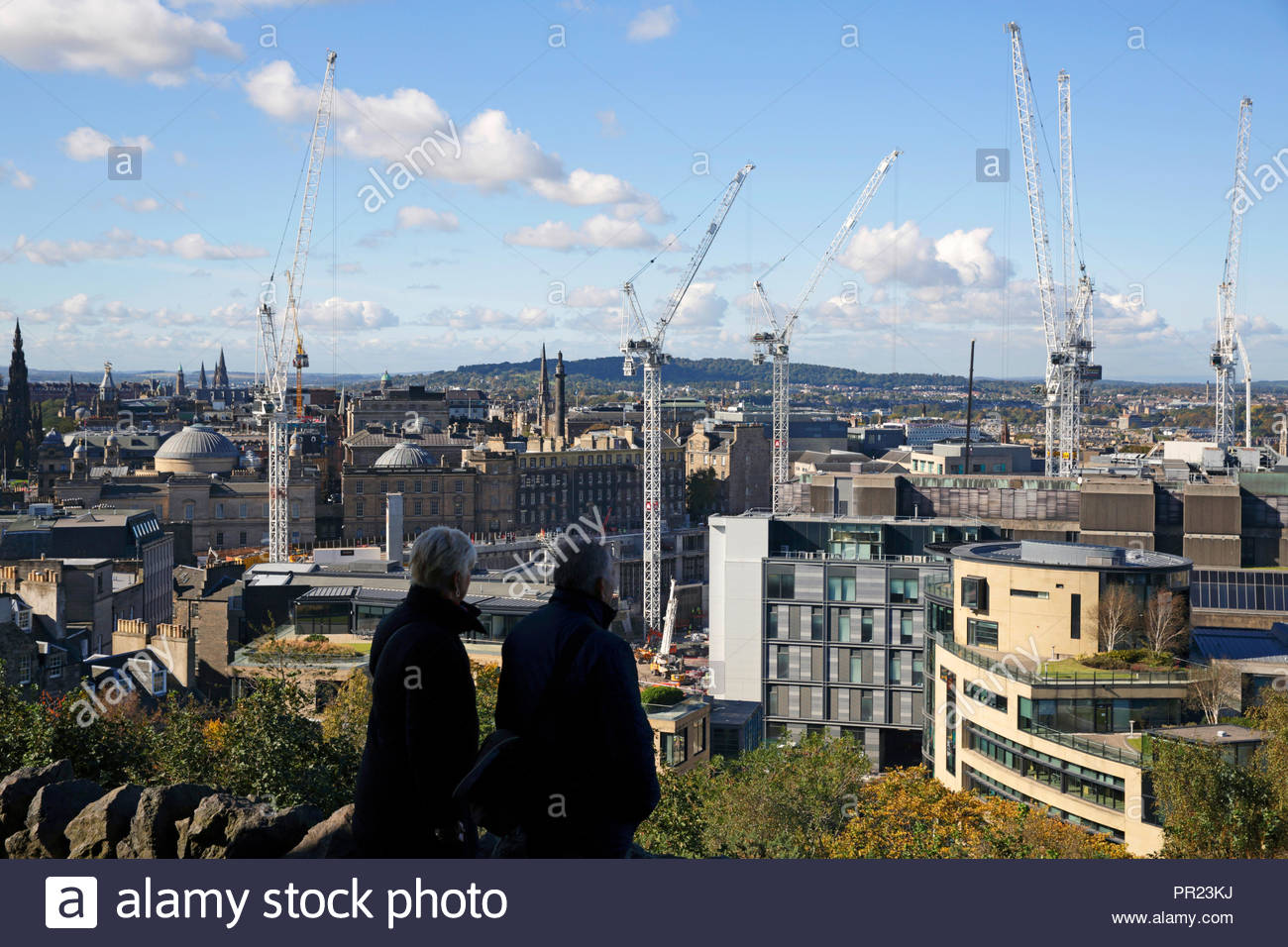 Two people viewing the cranes standing over the St James Centre demolition and redevelopment, Edinburgh Scotland Stock Photo