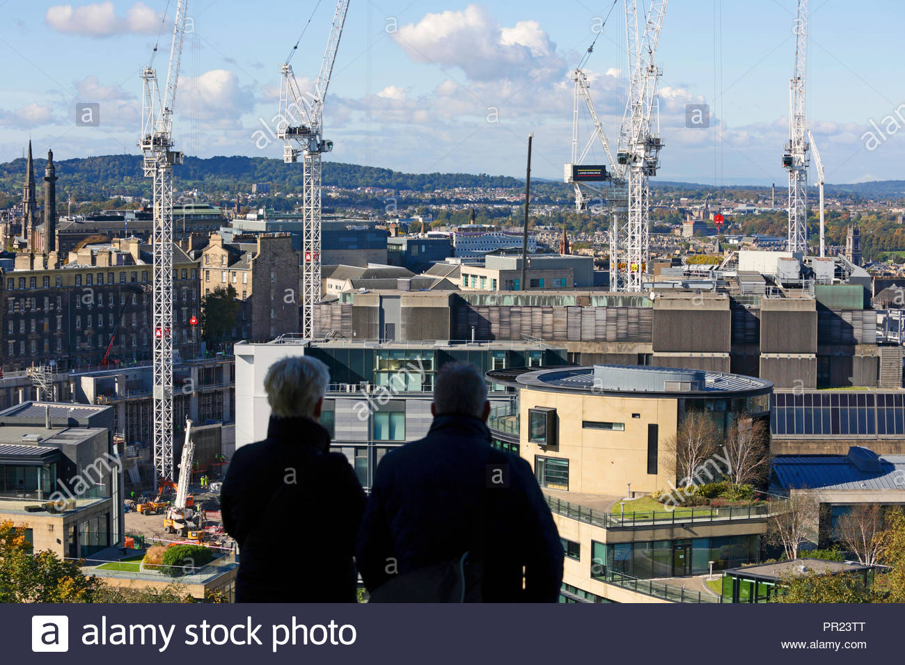 Two people viewing the cranes standing over the St James Centre demolition and redevelopment, Edinburgh Scotland Stock Photo