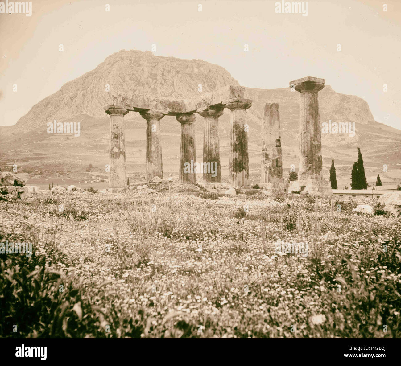 Old Corinth. Ruins of old Corinth. The Temple of Apollo. Agora Corinth in background. Temples on distant hilltop. Stock Photo