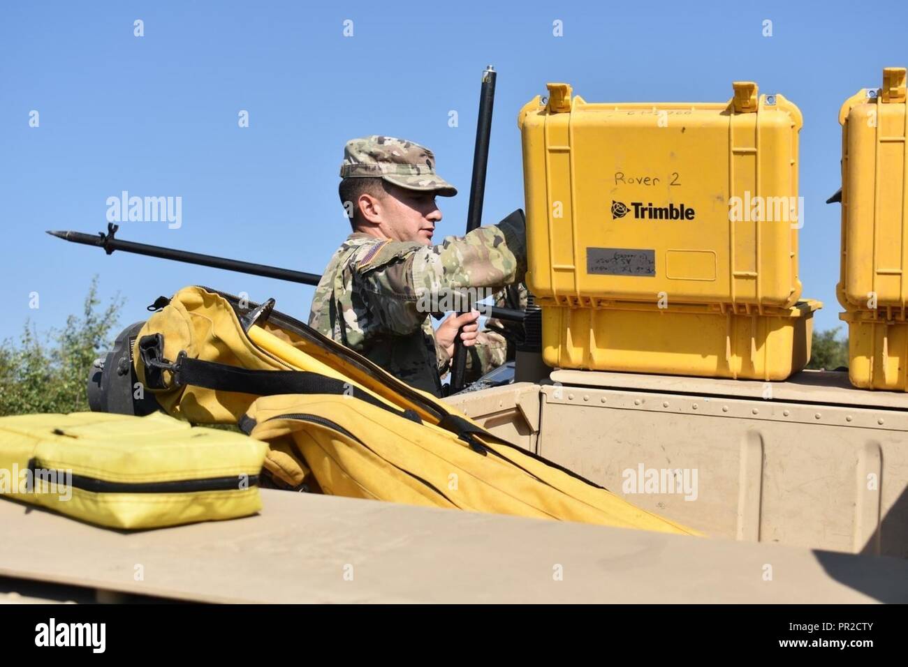 Spc. Charles Vincent prepares to assemble the mobile GNSS rovers, which are used to receive location and elevation coordinates from a satellite before transferring them to the stationary base receiver. The coordinate is then linked to the base receiver’s coordinates, averaged out, and sent back to the mobile rover. They are establishing the grade for a moving rail-target system at the non-standard live-fire range at Joint National Training Center, Cincu, Romania.  This project is part of Resolute Castle 17, an operation to help build relationships with the NATO alliance and enhance its capacit Stock Photo