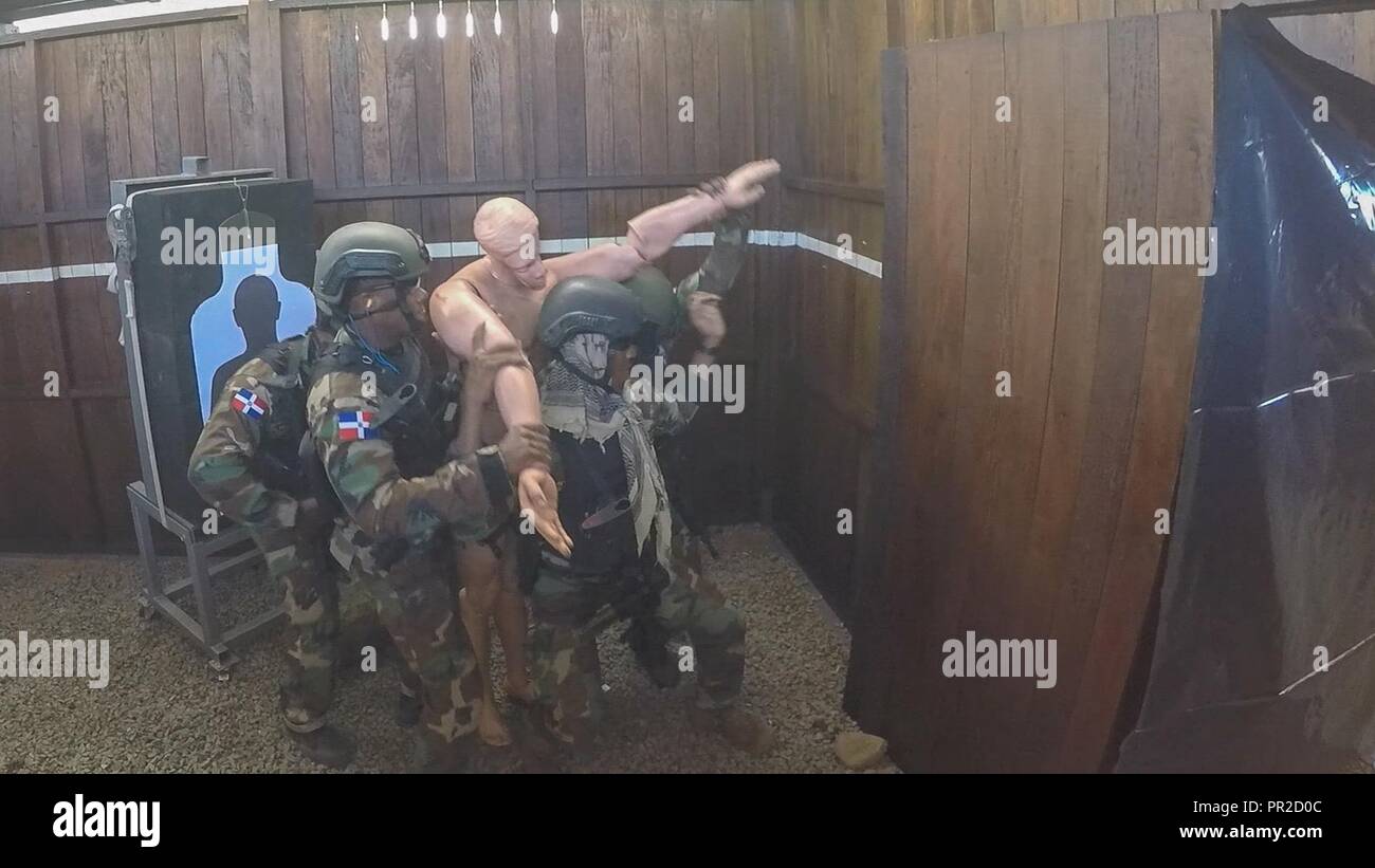 Dominican competitors rescue a simulated hostage in the combined assault event July 22, 2017, during Fuerzas Comando in Cerrito, Paraguay. The team takes the rescued hostage to a safe point to complete the event. Stock Photo