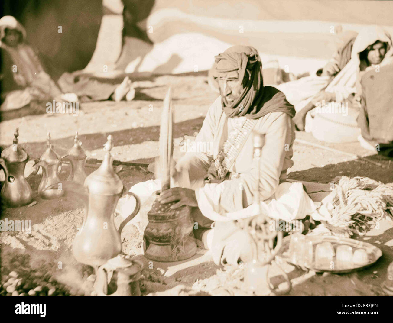 Bedouin life in Trans-Jordan. Pounding coffee to a rhythmic tune. 1920, Jordan Stock Photo