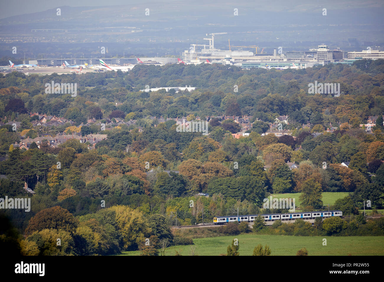 Alderley Edge, Cheshire, View from the Edge looking across the flat plain towards Manchester Airport as a Virgin Class 390 Pendolino crosses Stock Photo