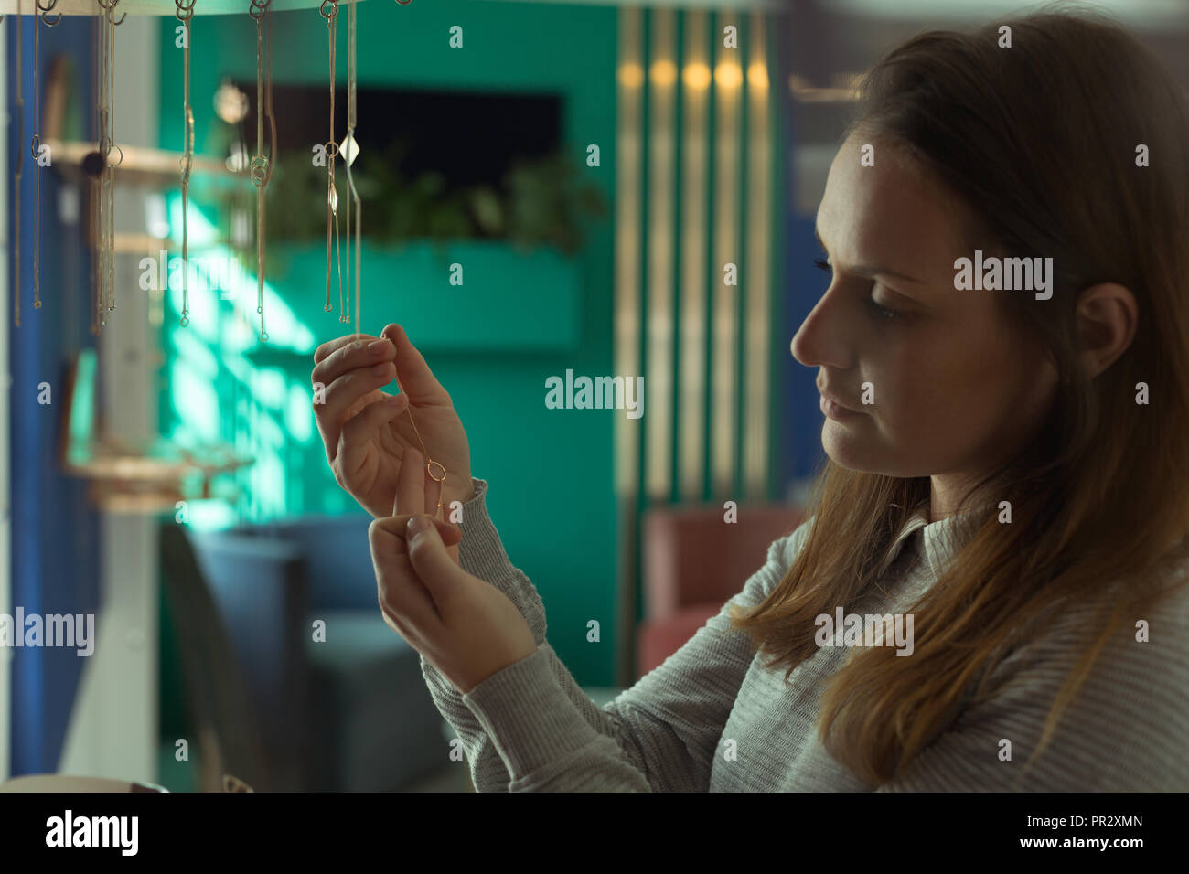 Female customer looking at jewelry in boutique shop Stock Photo