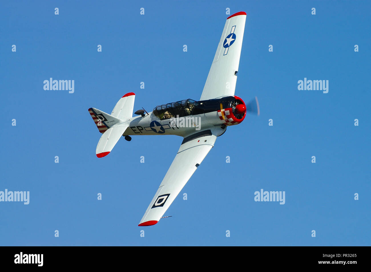 North American T-6 Harvard, Texan, owned by Maurice Hammond flying in blue sky at an airshow Stock Photo