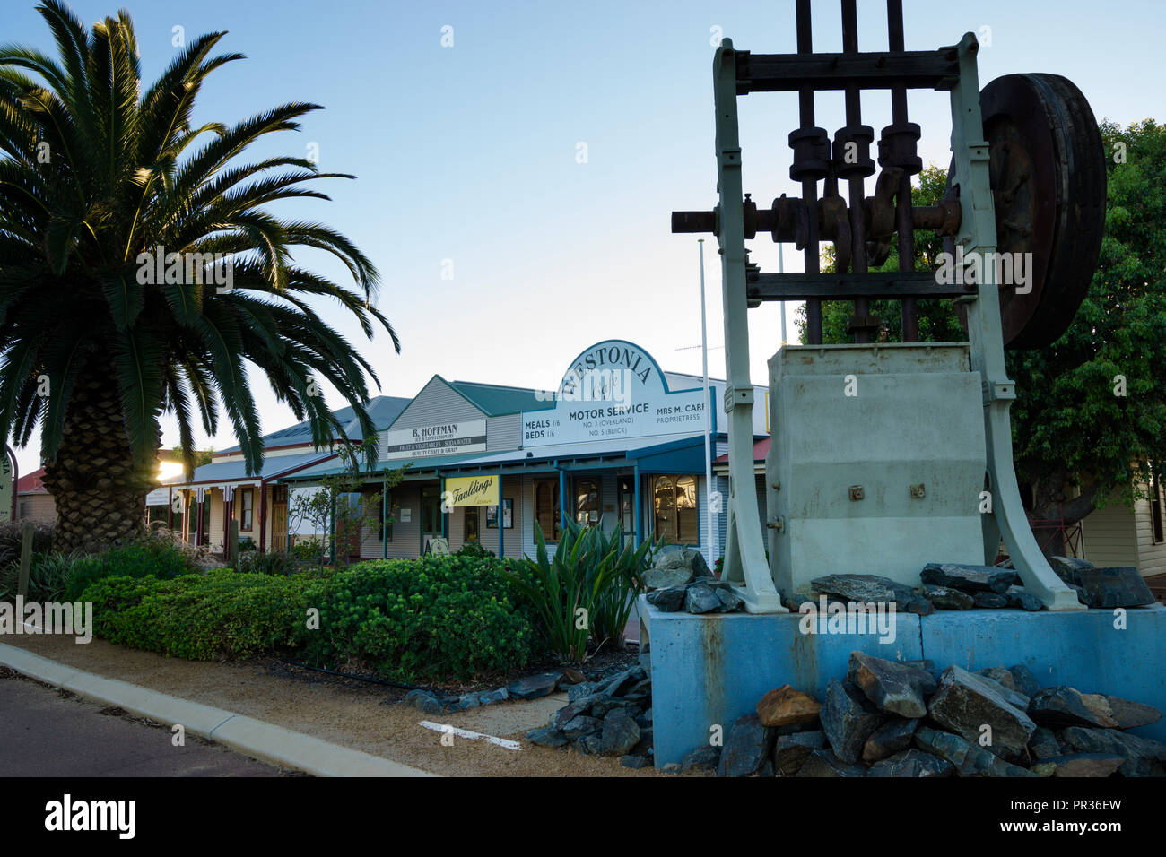 Old gold battery celebrating mining past in main street with historical shop facades in the background, Westonia Western Australia Stock Photo