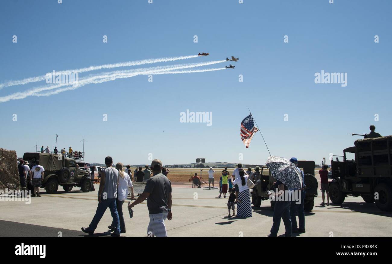 Service members and members of the local community watch as the Cascade Warbirds perform during the Skyfest 2017 Air Show and Open House at Fairhcild Air Force Base, Washington, July 29, 2017. SkyFest was an opportunity to give the local and regional community a chance to view Airmen and our resources. Stock Photo