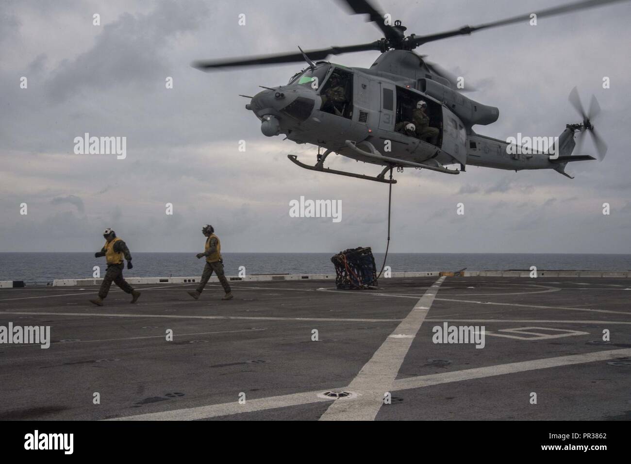 PACIFIC OCEAN (July 31, 2017). Marines assigned to Marine Medium Tiltrotor Squadron (VMM) 161 (reinforced) aboard the amphibious transport dock ship USS San Diego (LPD 22), return from hooking the pendant on the UH-1Y Venom on the ship’s flight deck. San Diego, part of the America Amphibious Ready Group, with embarked 15th MEU, is operating in the Indo-Asia Pacific region to strengthen partnerships and serve as a ready-response force for any type of contingency. Stock Photo