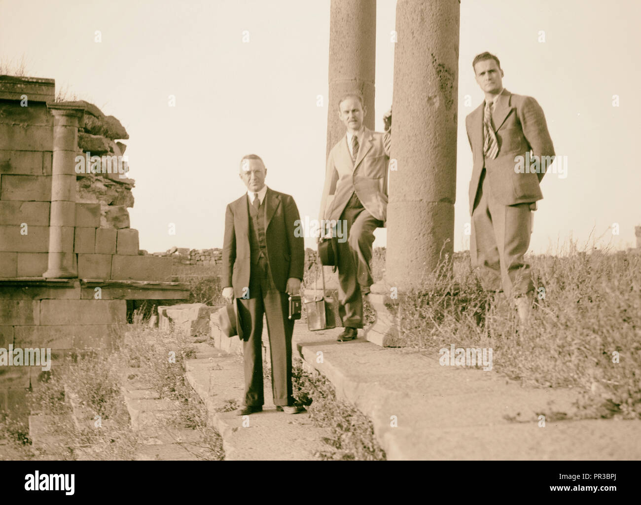 Jebel el-Druze & Hauran. Basra Eski Sham. Two pillars of colonnade with group. Torrence, Grossman, & Terrill. 1938, Syria, Buṣrá Stock Photo