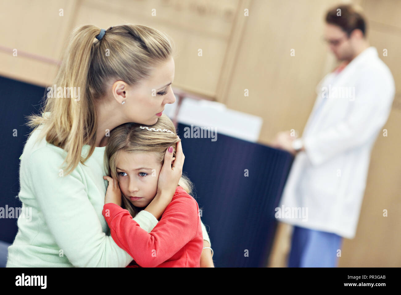 Little girl is crying while with her mother at a doctor on consultation Stock Photo