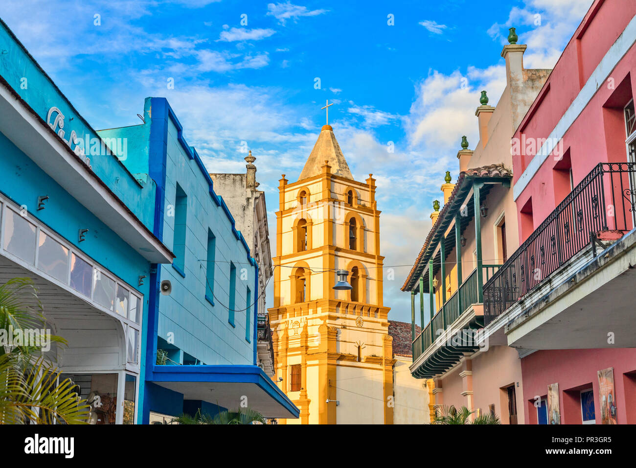 Nuestra Senora de la Soledad church and Spanish colonial colorful decorated houses with balconies, in the center of Camaguey, Cuba Stock Photo