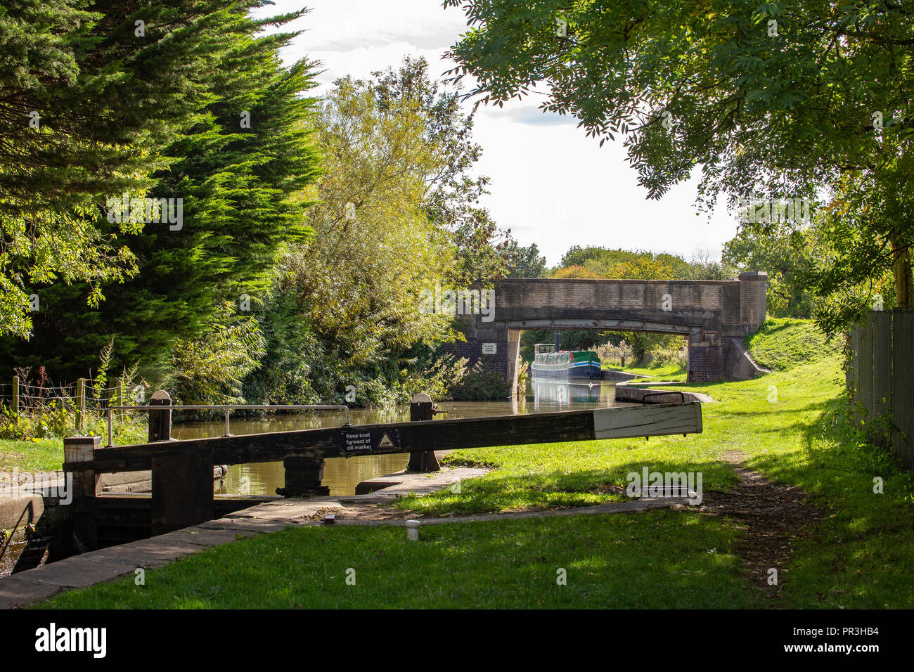 Moored narrow boat with bridge and lock on the Trent and Mersey canal in Cheshire UK Stock Photo