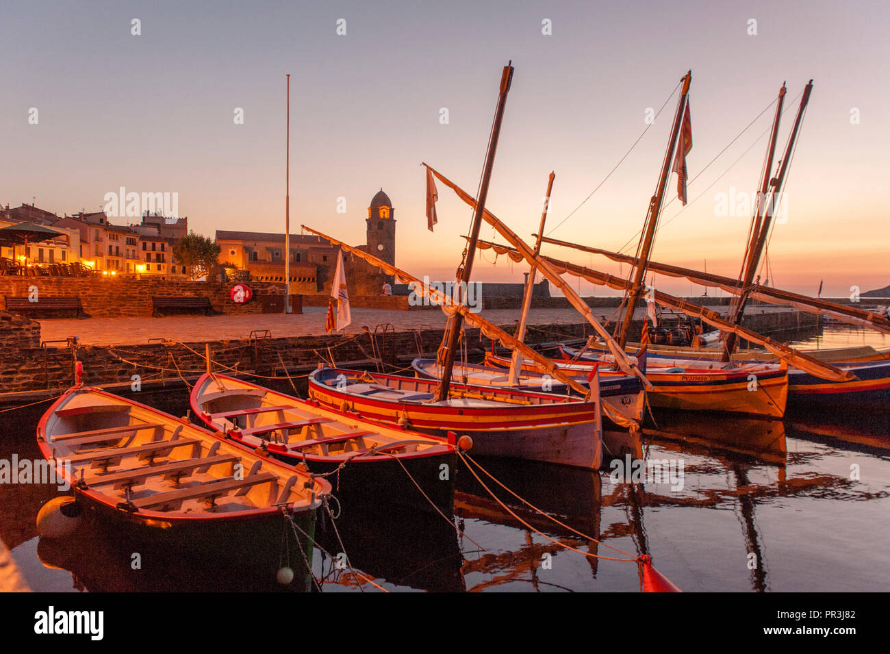 Traditional Catalan boats are moored in the port of Collioure, seen in the early morning light Stock Photo