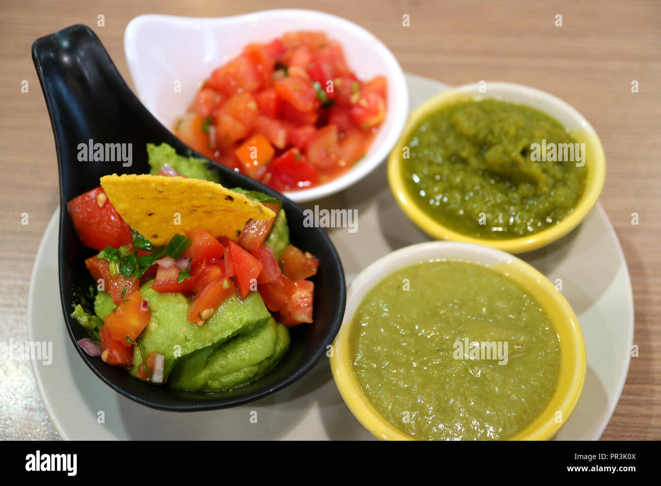 Guacamole and Various Salsa Sauce, Colorful Spicy Mexican Sauce on Wooden Table Stock Photo