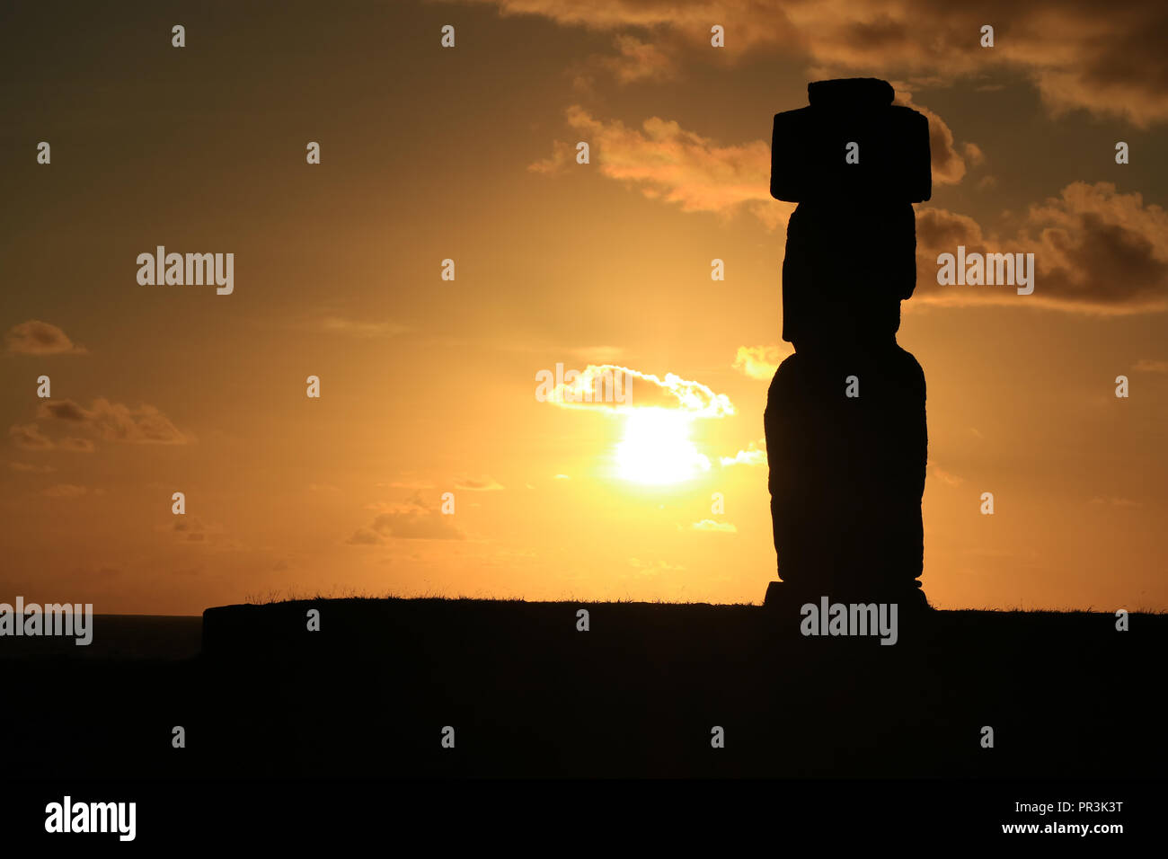 Breathtaking sunset over the Pacific ocean with Moai's silhouette of Ahu Tahai, Archaeological site in Easter Island, Chile Stock Photo