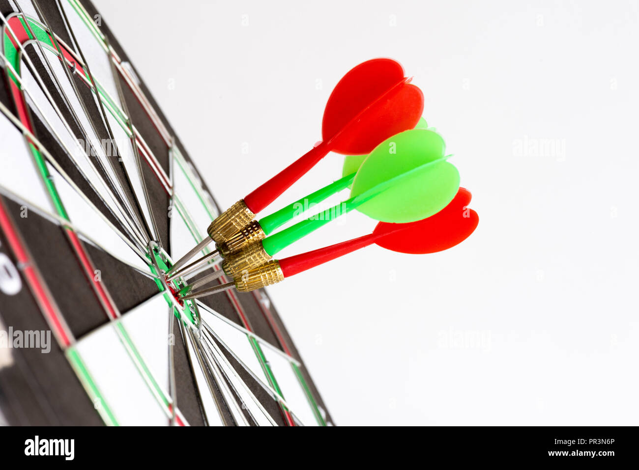 Close up shot green and red darts arrows in the target center. Business