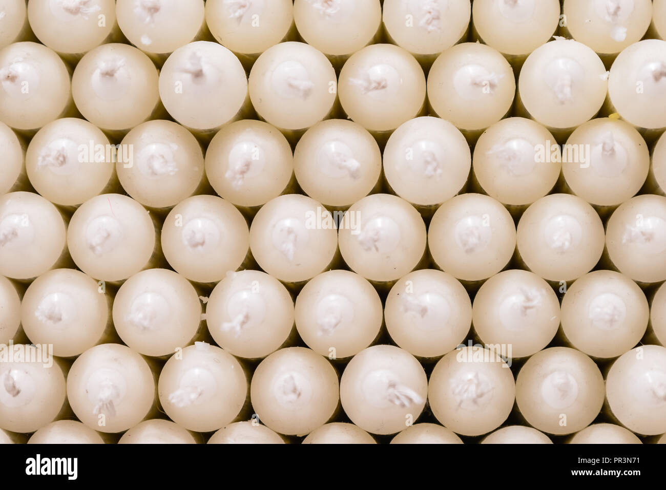 White paraffin stick candles arranged on shelves in a shop Stock Photo