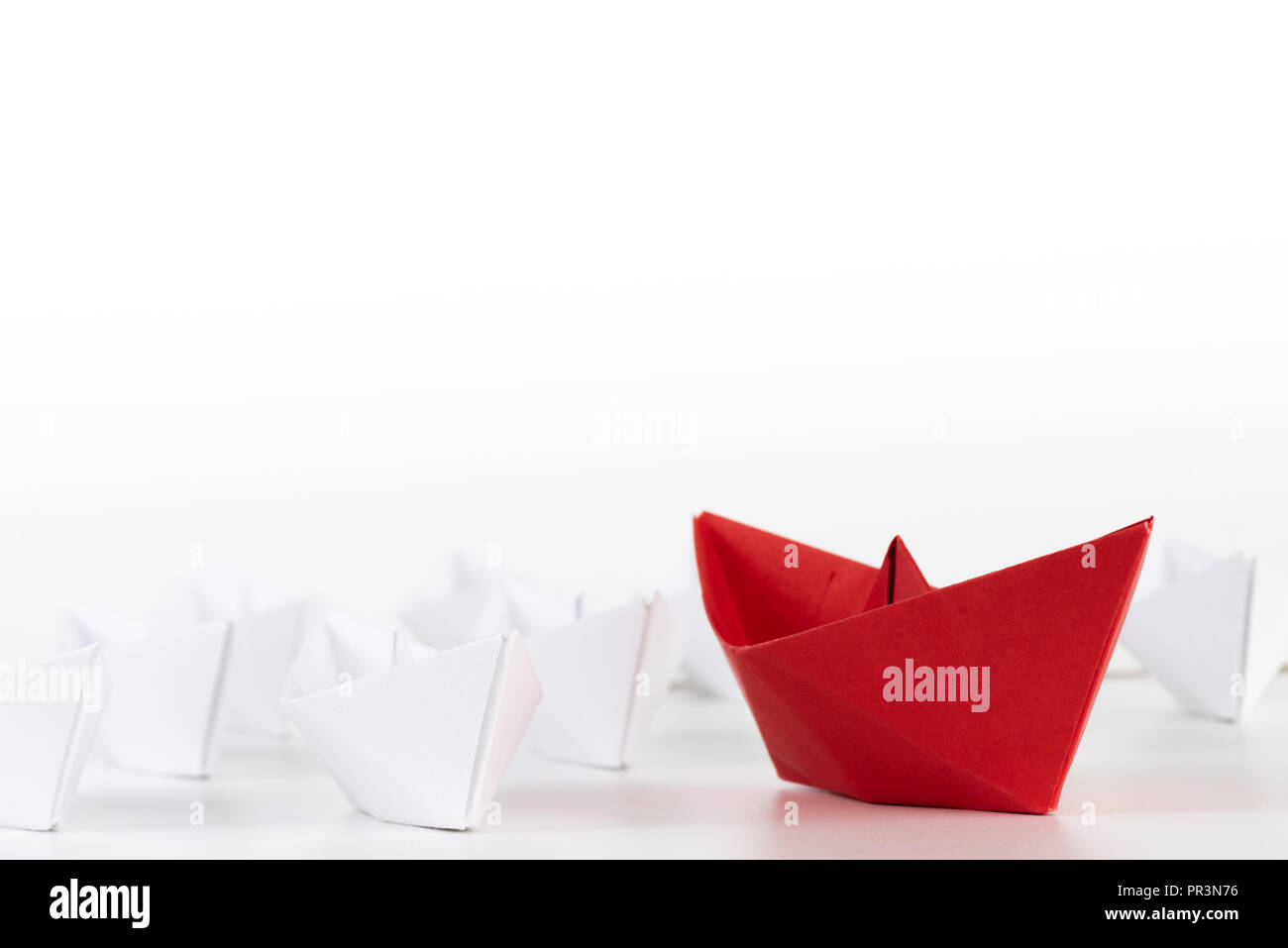 Leadership concept. red paper ship lead among white. One leader ship ...