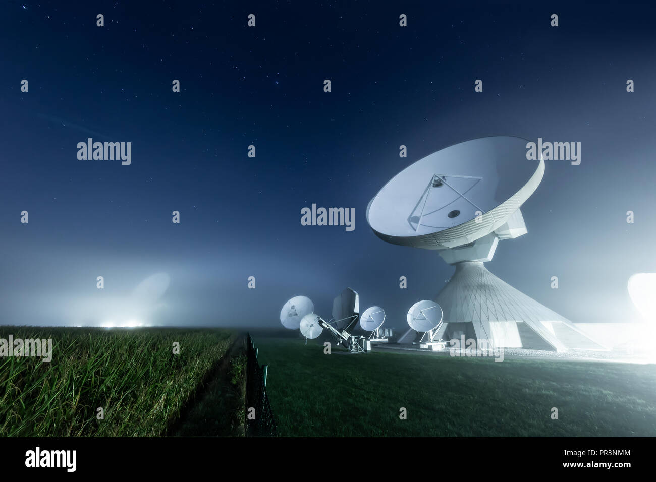 Satellite dishes at Raisting earth station in a foggy night Stock Photo