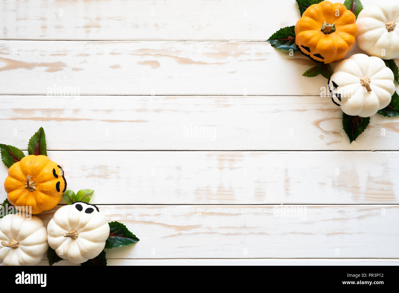 Top view of white and yellow ghost pumpkins on white wooden background ...