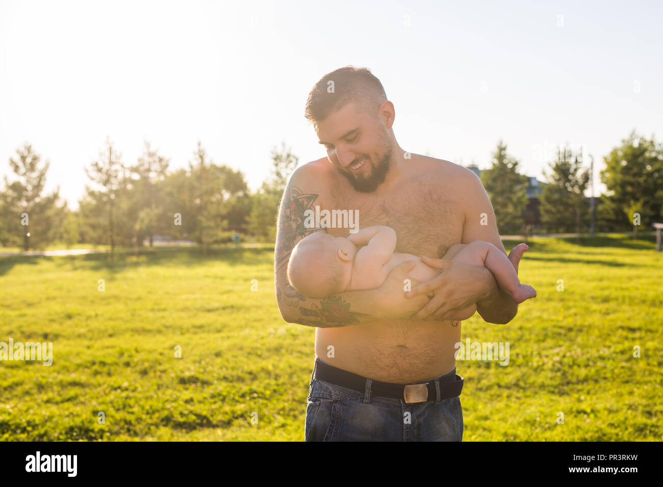 Happy father holding baby son, throwing baby in air. Concept of happy