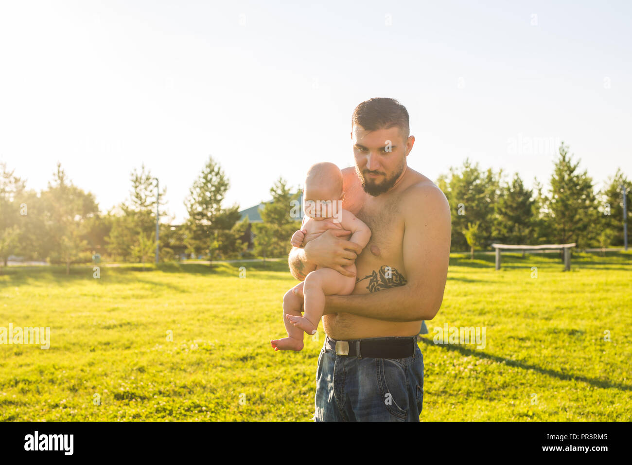 Happy father holding baby son, throwing baby in air. Concept of happy