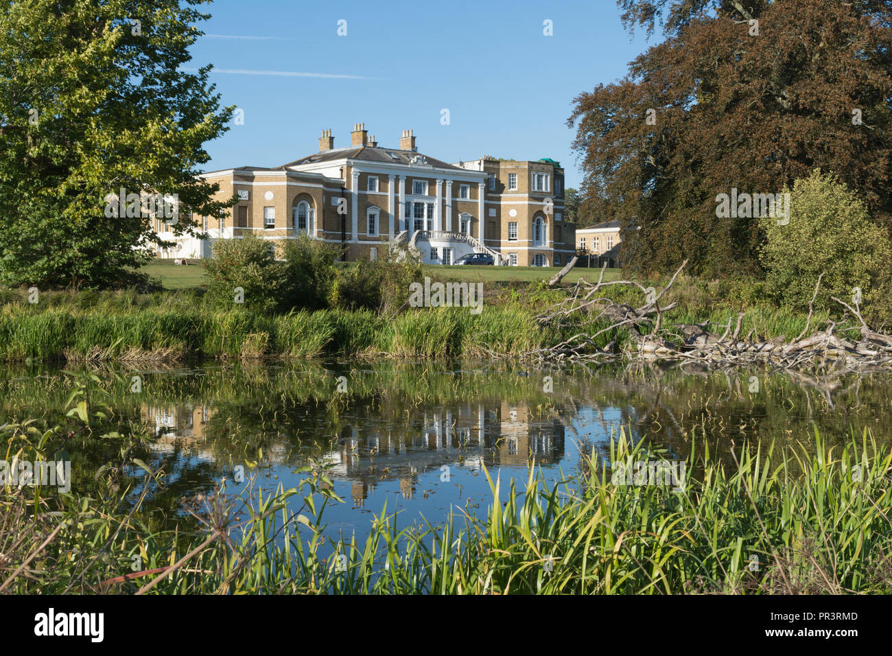 Waverley Abbey House, a charming Grade II listed Georgian mansion, reflected in the lake, among mature trees in autumn, Surrey, UK Stock Photo