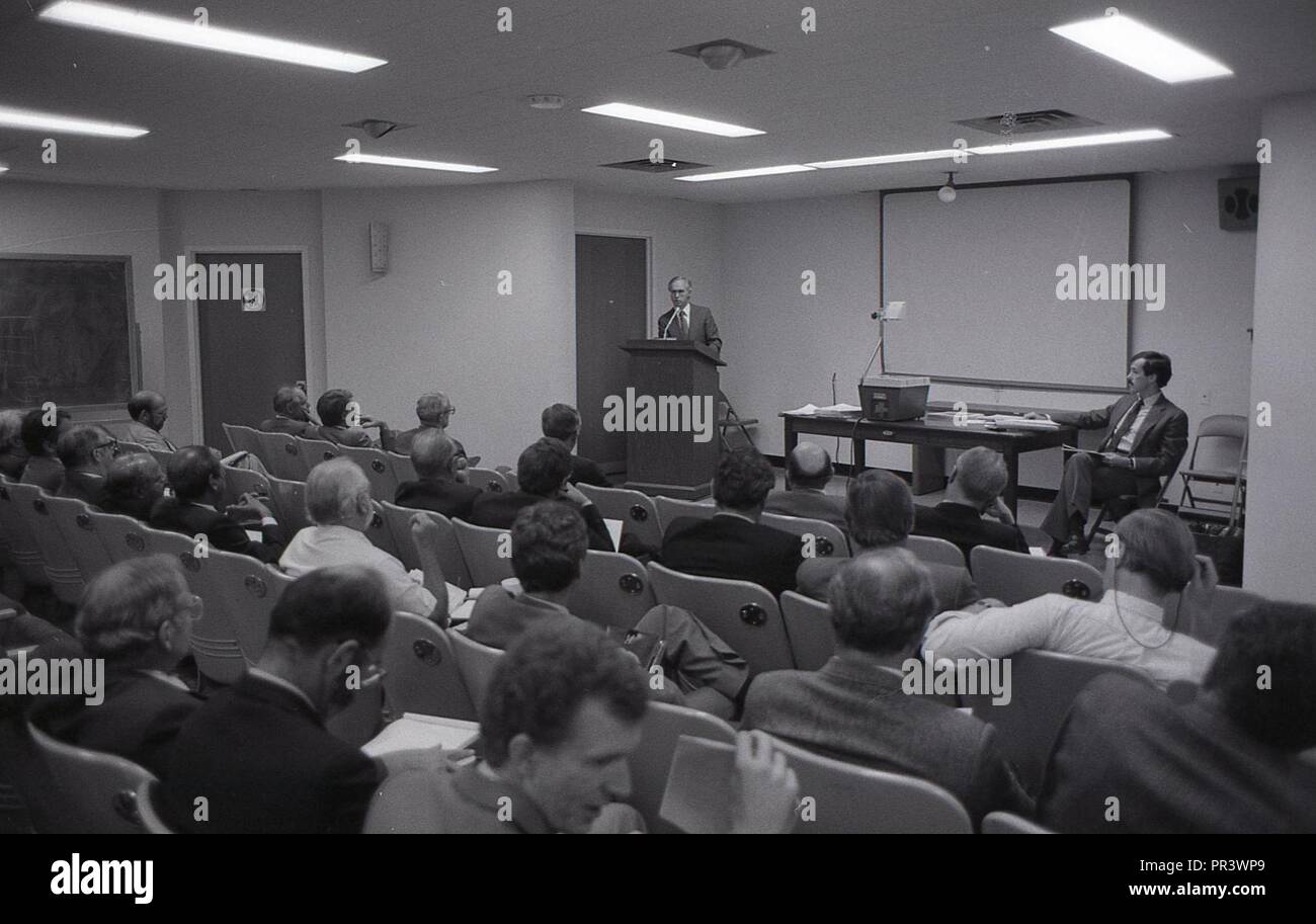 A MAN AT THE PODIUM GIVING A SPEECH IN FRONT OF A GROUP OF MEN Stock ...