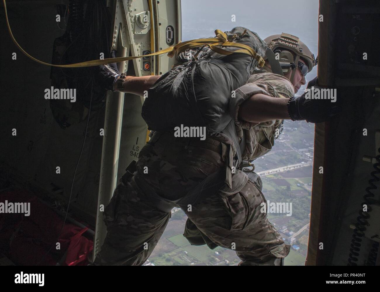 Staff Sgt. Justin Bender, 374th Operations Support Squadron survival, evasion, resistance and escape specialist, performs a visual confirmation over Yokota Air Base, Japan, July 28, 2017, during a static line jump training. Yokota SERE specialists conduct regular jump training to stay qualified and mission ready. Stock Photo