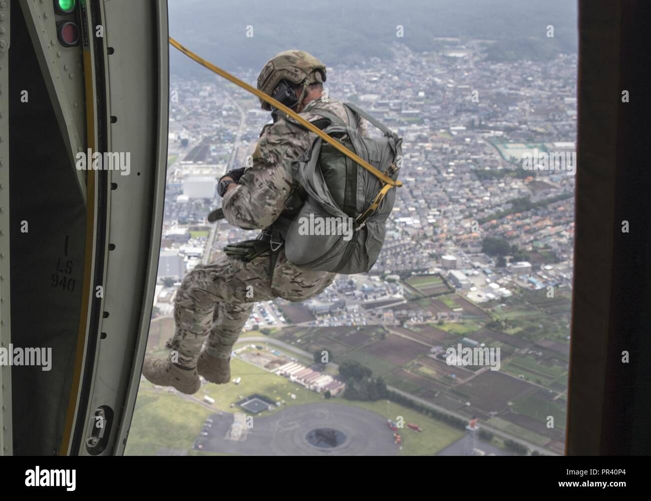 Tech. Sgt. Seth Sarrett, 374th Operations Support Squadron survival, evasion, resistance and escape specialist, jumps out of a C-130J Super Hercules during a training mission over Yokota Air Base, Japan, July 28, 2017. The training not only allowed the SERE to practice jumping, but it also allowed the Yokota aircrews to practice personnel drops and maintaining their qualifications. Stock Photo