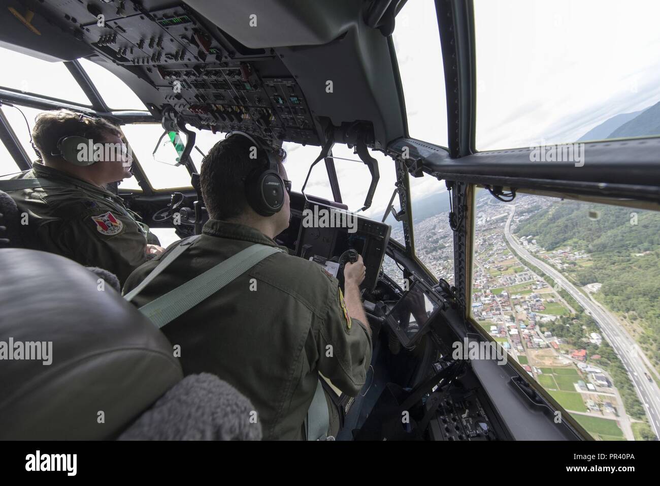 Lt. Col. Tyler Kern, 36th Airlift Squadron director of operations, and Maj. Scott Vander Ploeg, 36th Airlift Squadron assistant director of operations, fly over Yamanashi prefecture, Japan, July 28, 2017. The 36th AS crew members work daily to deliver airlift priorities to a larger area than any other U.S. base in the world. Stock Photo