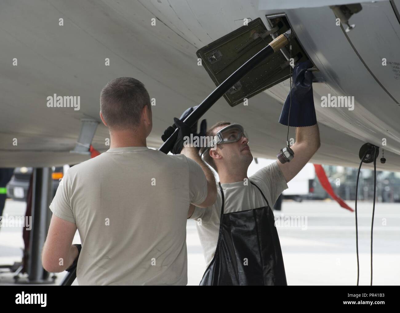 Maintainers connect a hydraulic hose to a C-5M Super Galaxy undergoing ...