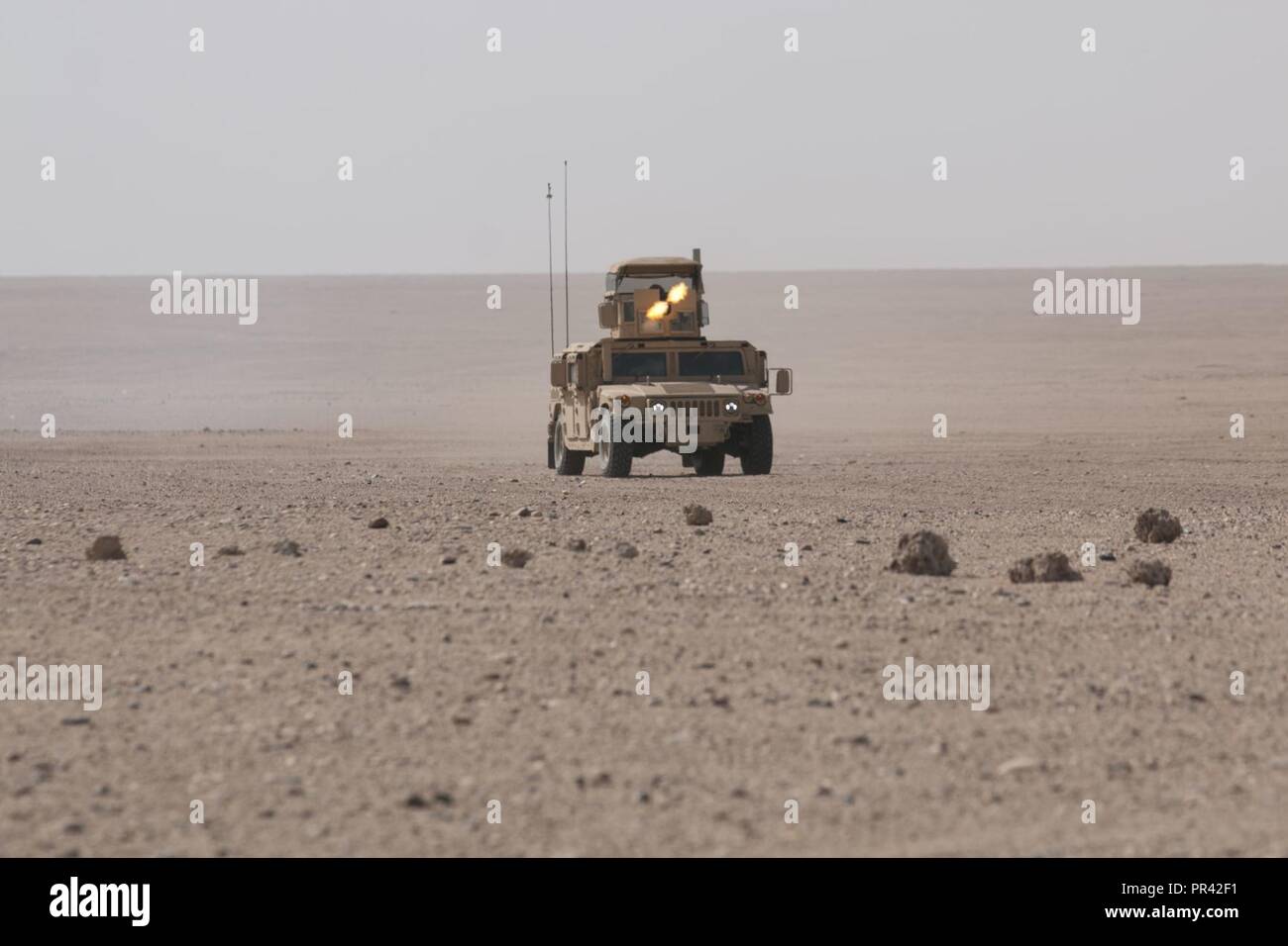 A gunner assigned to 215th Brigade Support Battalion, 3rd Armored Brigade Combat Team, 1st Cavalry Division engages the opposing forces on the drop zone at Udairi Range Complex, Kuwait, during air drop resupply training. As members of an armored brigade combat team, the Soldiers don't often get the chance to train with aircraft during resupply operations. Stock Photo