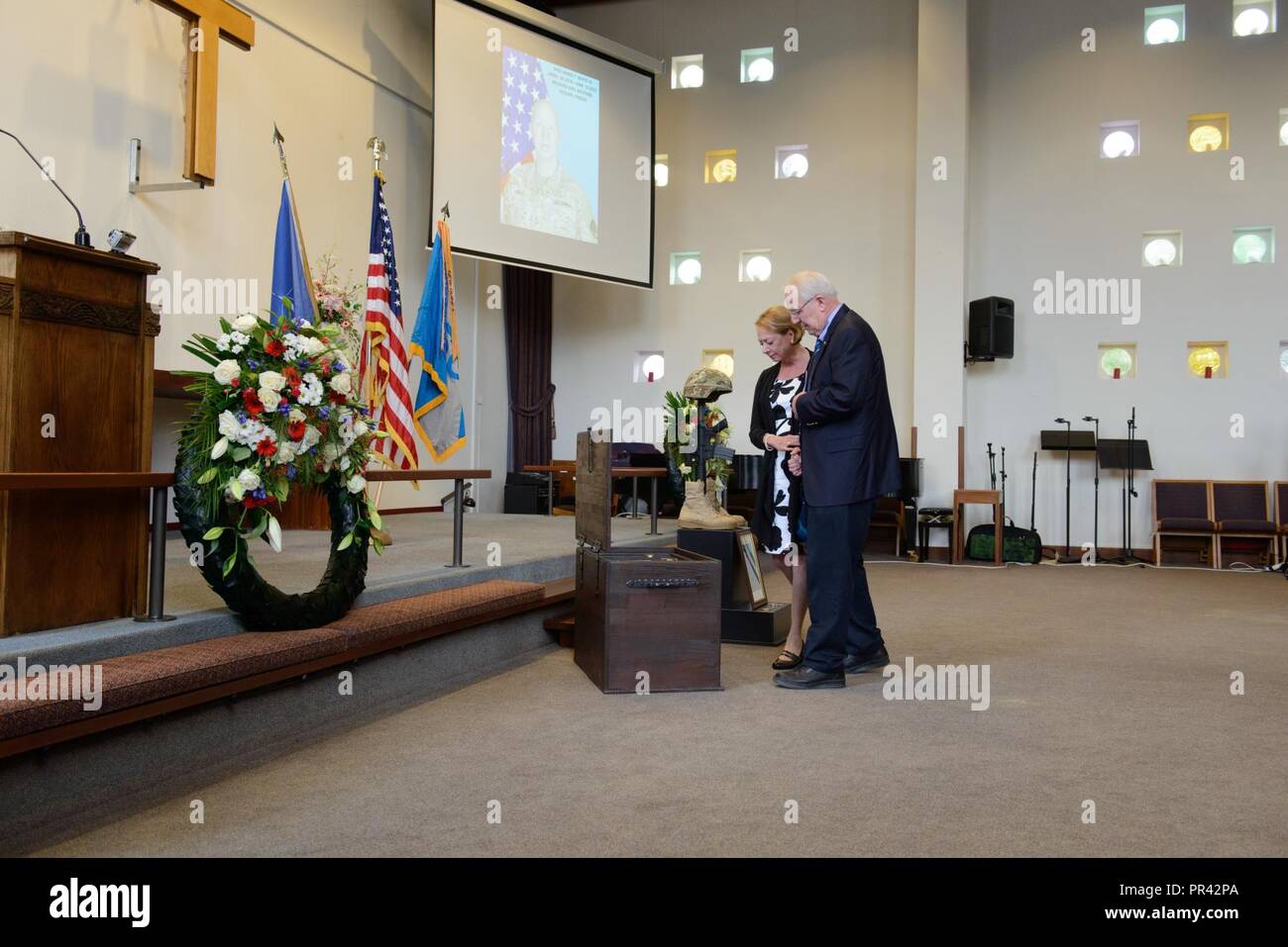 The father and step-mother of U.S. Army Master Sgt. James T. White IV, collect their thoughts in front of the shadow box in the Chapel of Joint Forces Command Brunssum, Netherlands, July 25, 2017. Stock Photo