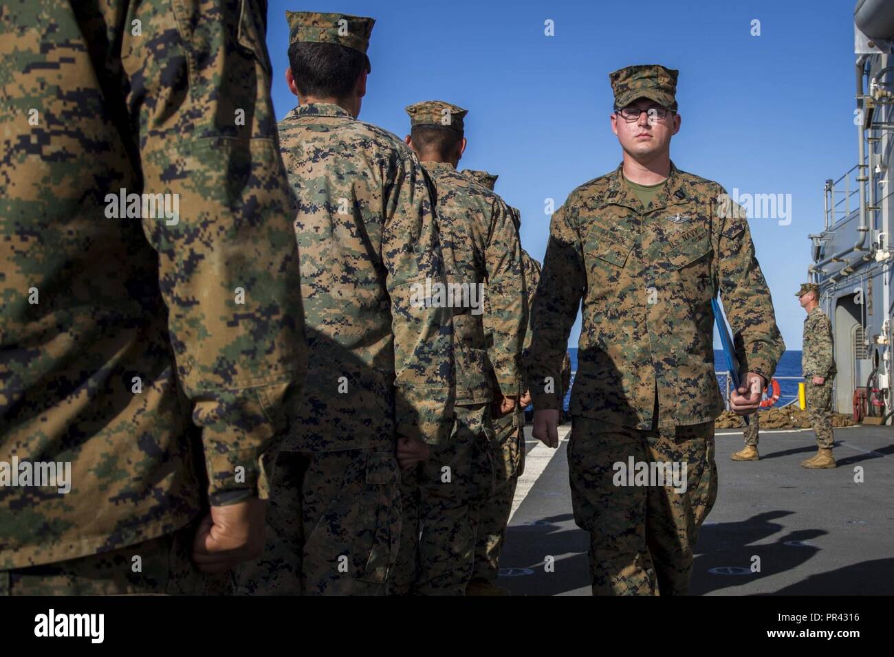 Navy Seaman Charles Patrick, a hospital man attached to Task Force Koa Moana 17 marches after receiving his Enlisted Fleet Marine Force Warfare Specialist Insignia (FMF) award on the USNS Sacagawea, July 28, 2017. The FMF award is given to Navy enlisted personnel who are attached to deployable U.S. Marine Corps units and pass verbal and written exams qualifying the individual adept in Marine Corps history, and knowledge. Stock Photo