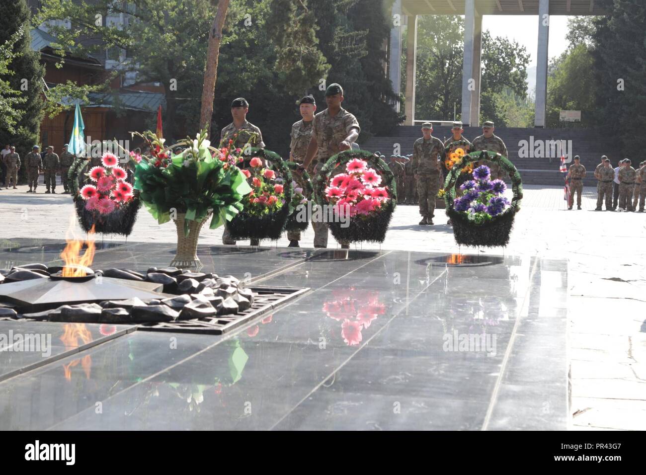United Kingdom soldiers lay flowers in in front of a World War II ...