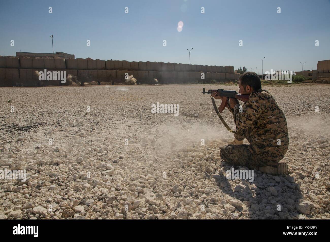 A Syrian Arab trainee fires his rifle at a marksmanship range in Northern Syria, July 31 2017. The Syrian Democratic Forces continue to recruit and train Syrians of all ethnicities who are passionate about joining the counter-ISIS fight to eliminate terror from their home. The SDF have proven themselves able to conduct clearance operations while respecting the Law of War in their liberation of Raqqah. Stock Photo