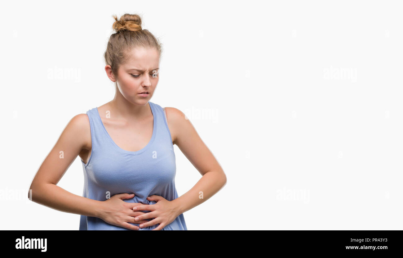 Young blonde woman with hand on stomach because indigestion, painful illness feeling unwell. Ache concept. Stock Photo