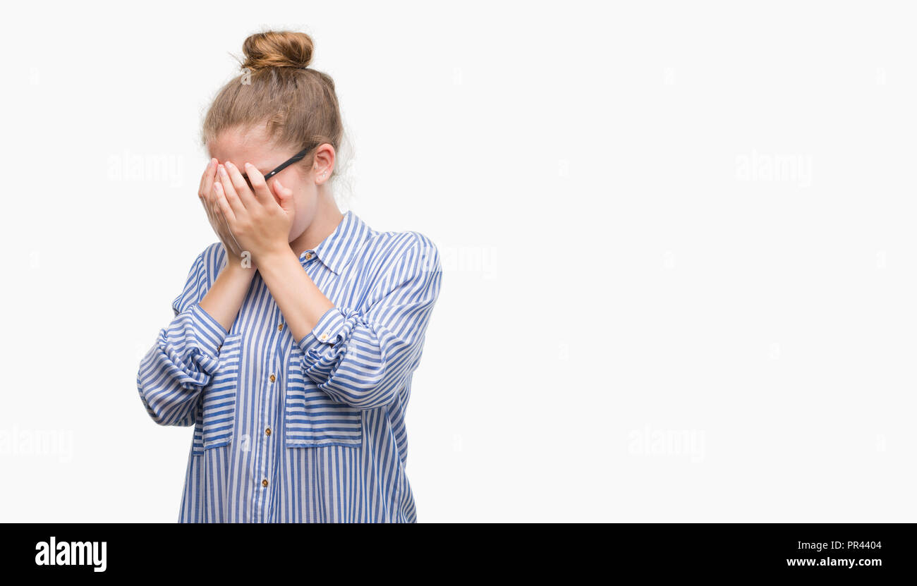 Young blonde business woman with sad expression covering face with hands while crying. Depression concept. Stock Photo